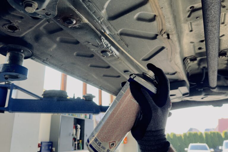 Spraydose, welche ein Auto von unten besprüht